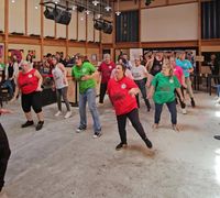 Grand groupe qui danse la zumba dans la halle